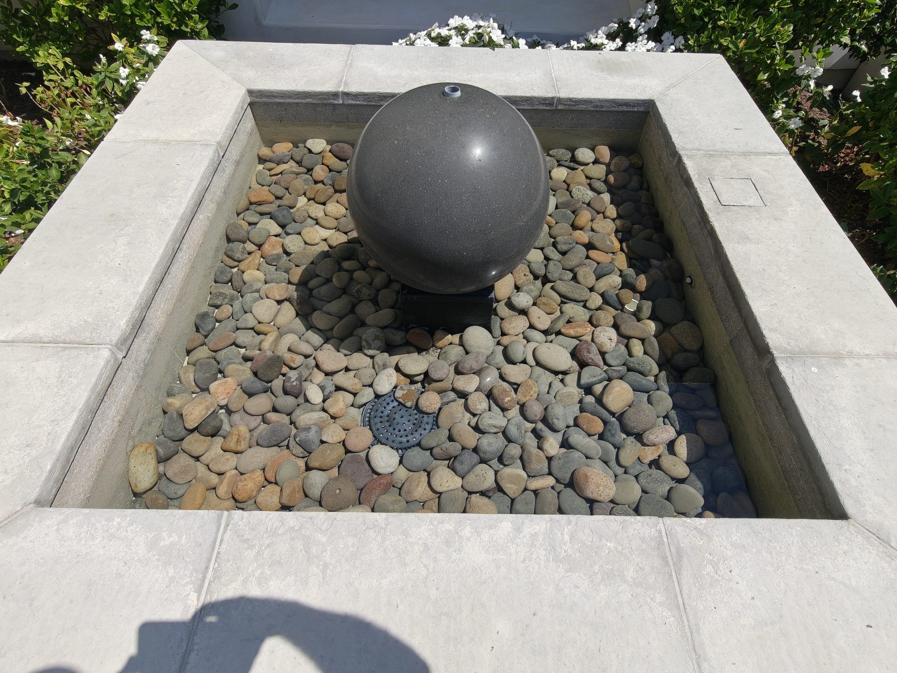 Courtyard orb fountain and pebble basin